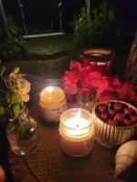 een tafel met kaarsen en bloemen en een mand met aardbeien bij Chalé dos Ventos in Amontada