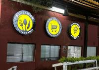 a building with three signs on the side of it at Chalé Gratidão - Camping Carrion - ITU in Itu