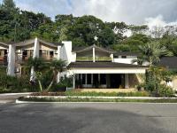 a white house with palm trees and a street at Hotel Ladera in Boquete