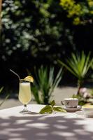 Un vaso de bebida sobre una mesa con una taza. en Hotel Subra Atrium, en Herceg-Novi