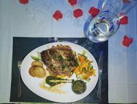 ParakouAlmadies Prestige的桌上有一盘有肉和蔬菜的食物