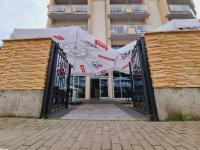 ein Tor zu einem Gebäude mit einem weißen Vordach in der Unterkunft Hotel White in Krynica Morska