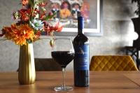 uma garrafa de vinho e uma taça sobre uma mesa em Het Maashotel em Broekhuizen