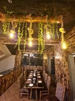 Un comedor con una mesa larga y luces. en Silk Route Resort, en Gulmit