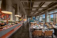 Narat新疆华美胜地那拉提英迪格酒店的餐厅里有桌椅和窗户。