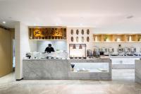 um homem parado atrás de um balcão num restaurante em Atour Hotel Qingdao May Fourth Square Yunxiao Road em Qingdao