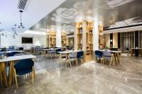 um restaurante com mesas e cadeiras em uma sala em Atour Hotel Qingdao May Fourth Square Yunxiao Road em Qingdao