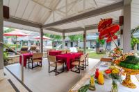 Un patio al aire libre con mesas y sillas rojas. en Dewi Sri Hotel, en Legian