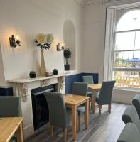 una sala da pranzo con tavoli e sedie e un camino di Lynton House Hotel a Teignmouth