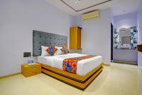 Un dormitorio con una gran cama blanca con almohadas de colores. en FabHotel Nidhivan Palace - Udhna Darwaja, en Surat