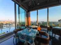 北京市にあるThe Purple Horse Hotel Beijingのテーブルと椅子と大きな窓のあるレストラン