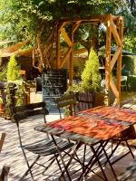 una mesa de madera y 2 sillas con copas de vino. en Hôtel Amaya, en Ambarès-et-Lagrave