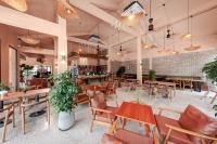 ein Restaurant mit Holztischen und Stühlen und einer Ziegelwand in der Unterkunft La Sen Village in Ninh Bình