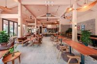 ein Restaurant mit Holztischen, Stühlen und Pflanzen in der Unterkunft La Sen Village in Ninh Bình