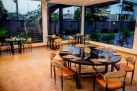a restaurant with tables and chairs and large windows at Gordonsville Escape Boutique Hotel in Port Harcourt