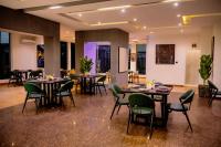 a dining room with tables and green chairs at Gordonsville Escape Boutique Hotel in Port Harcourt