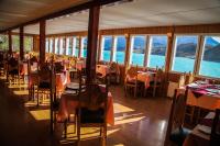 Hostería Pehoe في توريس ديل باين: مطعم مع طاولات وكراسي وإطلالة على المحيط