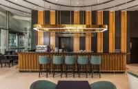 ein Restaurant mit einer Bar mit Stühlen und einem Kronleuchter in der Unterkunft Wyndham Soleil Danang - Free Two ways Airport Transport in Đà Nẵng