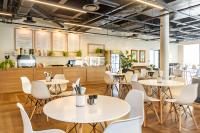 a restaurant with white tables and chairs and a counter at One Thibault Hotel by ITC Hospitality in Cape Town