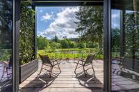three chairs sitting on a porch looking out at a lake at Hillview Hotel Grandvoir in Neufchâteau
