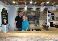 un homme et une femme debout devant un comptoir dans l'établissement s' Kännele Ferienwohnungen, à Mudau