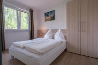 ein Schlafzimmer mit einem Bett mit weißen Laken und einem Fenster in der Unterkunft Ferienpark Rübezahl am Müggelsee, Haus 20 Mohn mit eigener Sauna, idealer Ort für Natur- und Erholungssuchende, für Radfahrer und Familien mit Kindern in Berlin