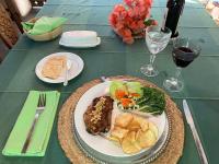 een tafel met een bord eten en glazen wijn bij Posada Casa del Sol in Caracas