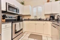 eine Küche mit weißen Schränken und schwarzen Geräten in der Unterkunft Beautiful 1500 s f 3 Bd - 2 Ba condo overlooking stream and golf course in Myrtle Beach
