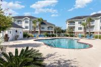 ein Swimmingpool vor zwei großen Häusern in der Unterkunft Beautiful 1500 s f 3 Bd - 2 Ba condo overlooking stream and golf course in Myrtle Beach