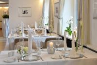 Una mesa con velas blancas y flores blancas sobre ella. en Parkhotel Oberhausen, en Oberhausen