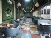 een eetkamer met stoelen en tafels in een restaurant bij Hotel Oval in Surabaya