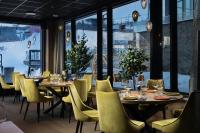 バイトストーレンにあるRiddergaarden Hotel & Mountain Lodge, Beitostølenのテーブルと椅子と大きな窓のあるレストラン