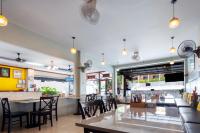 a restaurant with tables and chairs and a bar at Kata Sun Beach Hotel in Kata Beach