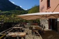 un patio con mesas, sillas y sombrillas en Tandem, en Vicdessos