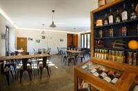 un restaurante con mesas, sillas y botellas de vino en Tandem, en Vicdessos