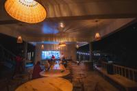 Un restaurante con mesas y sillas de madera y luces. en Mara Hilltop, en Sekenani