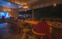 un grupo de personas sentadas en una mesa en un restaurante en Mara Hilltop, en Sekenani