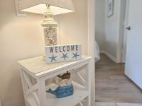 ein weißer Beistelltisch mit einem Willkommensschild darauf in der Unterkunft Serene 2 bed, 2 bath lodge, with amenities, 101AC lodge in Myrtle Beach