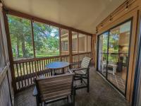 eine abgeschirmte Veranda mit einem Tisch und Stühlen in der Unterkunft Serene 2 bed, 2 bath lodge, with amenities, 101AC lodge in Myrtle Beach