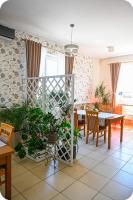 ein Esszimmer mit einem Tisch und einigen Pflanzen in der Unterkunft Hotel Gracja in Brok