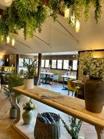 ein Raum mit Tischen und Topfpflanzen in einem Restaurant in der Unterkunft Shepherd's Huts at Hall Farm in Ashby cum Fenby