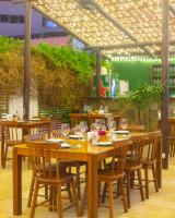 un tavolo e sedie in legno con bicchieri da vino sopra di Valencia Hotel Natal a Natal