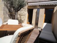 a patio with a table and chairs and a building at Les toîts d&#39;Uzès in Uzès