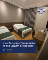 una habitación de hotel con dos camas y una mesa en Regis Hotel II, en Registro