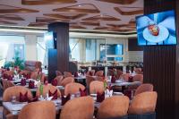 a dining room with tables and chairs and a tv at Town Square Suites in Hyderabad