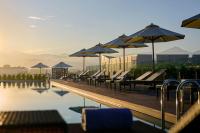 una piscina con bancos y sombrillas junto al agua en AC Hotel by Marriott Ipoh, en Ipoh
