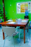 un tavolo in legno con sedie e una parete verde di TJ Comfort Villa Suriname a Paramaribo