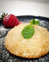 Un postre con una fresa en un plato negro. en Su Arghentu Country Hotel, en Laerru