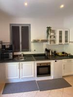 eine Küche mit weißen Schränken und einer Spüle in der Unterkunft Villa Serenice - F2 au calme, climatisé, WIFI et parking gratuit in Nizza
