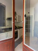 eine Küche mit weißen Schränken und einer Glasschiebetür in der Unterkunft Villa Serenice - F2 au calme, climatisé, WIFI et parking gratuit in Nizza